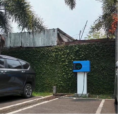 Charger VinFast biru berdiri di satu slot parkir